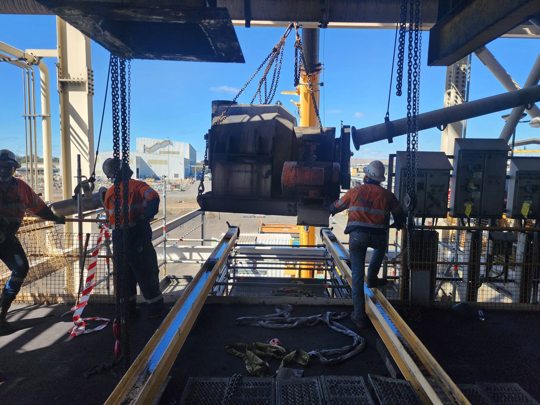 Shutdown crew lifting a heavy component with chain blocks on fixed plant